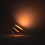 Philips Hue Iris Tischleuchte, schwarz, mit warmem Lichtschein.