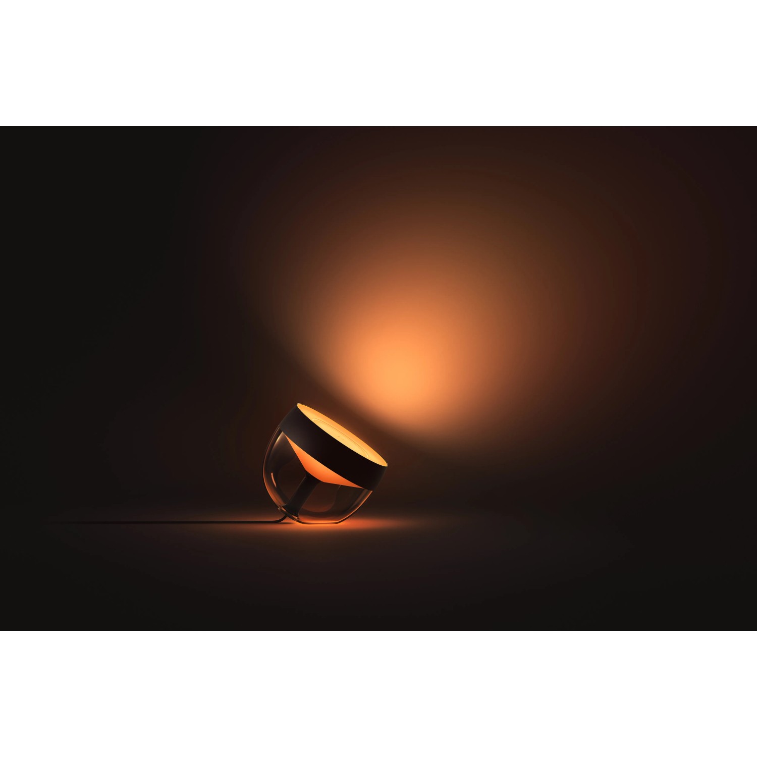 Philips Hue Iris Tischleuchte, schwarz, mit warmem Lichtschein.