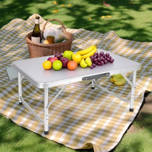 Weißer Relaxdays Aluminium Campingtisch, klappbar & höhenverstellbar, mit Obst auf Picknickdecke im Grünen.