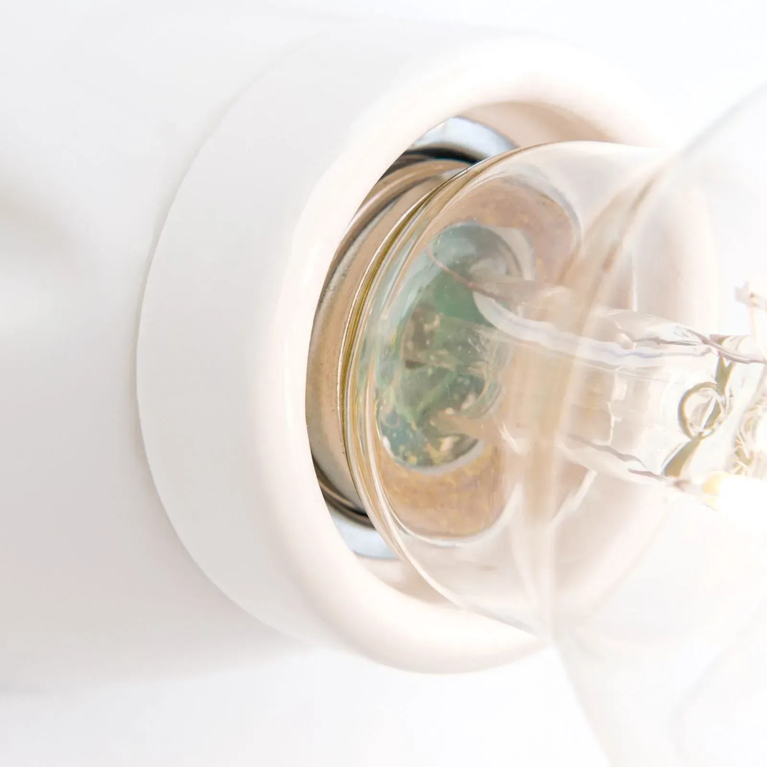 Detailaufnahme: Weiße Keramik Wandleuchte E27 mit eingesetztem Leuchtmittel.