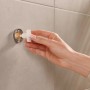 Montage des Tesa Toilettenpapierhalters Moon Schwarz Matt mit Klebelösung an der Wand.
