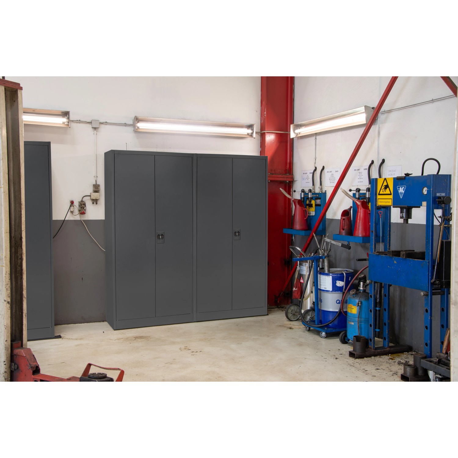 Anthrazitfarbener Rikta Metallschrank (168x80x40cm) mit Flügeltüren und vier Einlegeböden im Werkstatt-Umfeld.