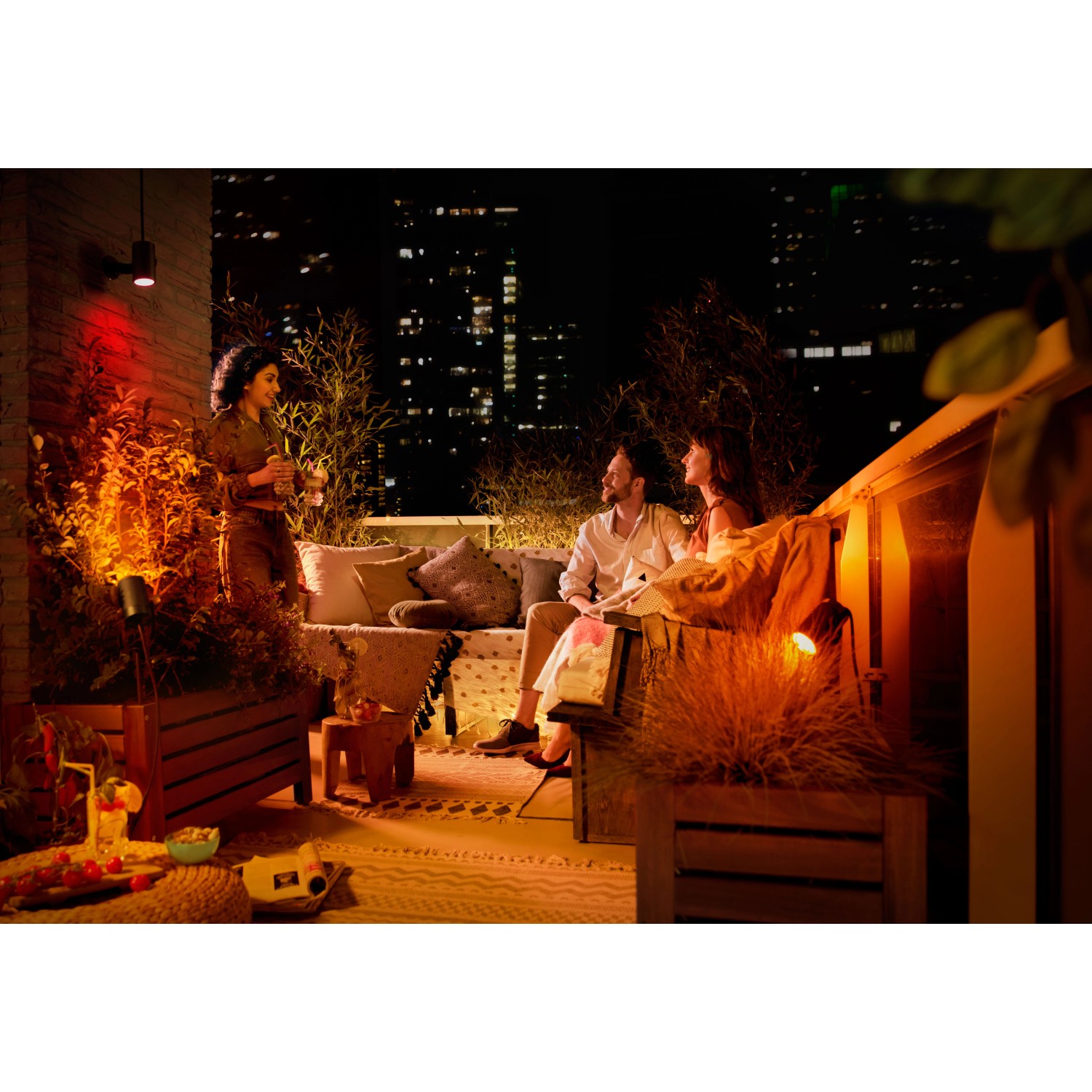 Szene mit Philips Hue Lily LED-Spot Außenleuchten, die Garten und Terrasse farbig beleuchten.