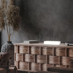 Weiße, dimmbare Brilo LED-Tischleuchte Muro S B-Smart mit 9W auf einem Holzschrank.