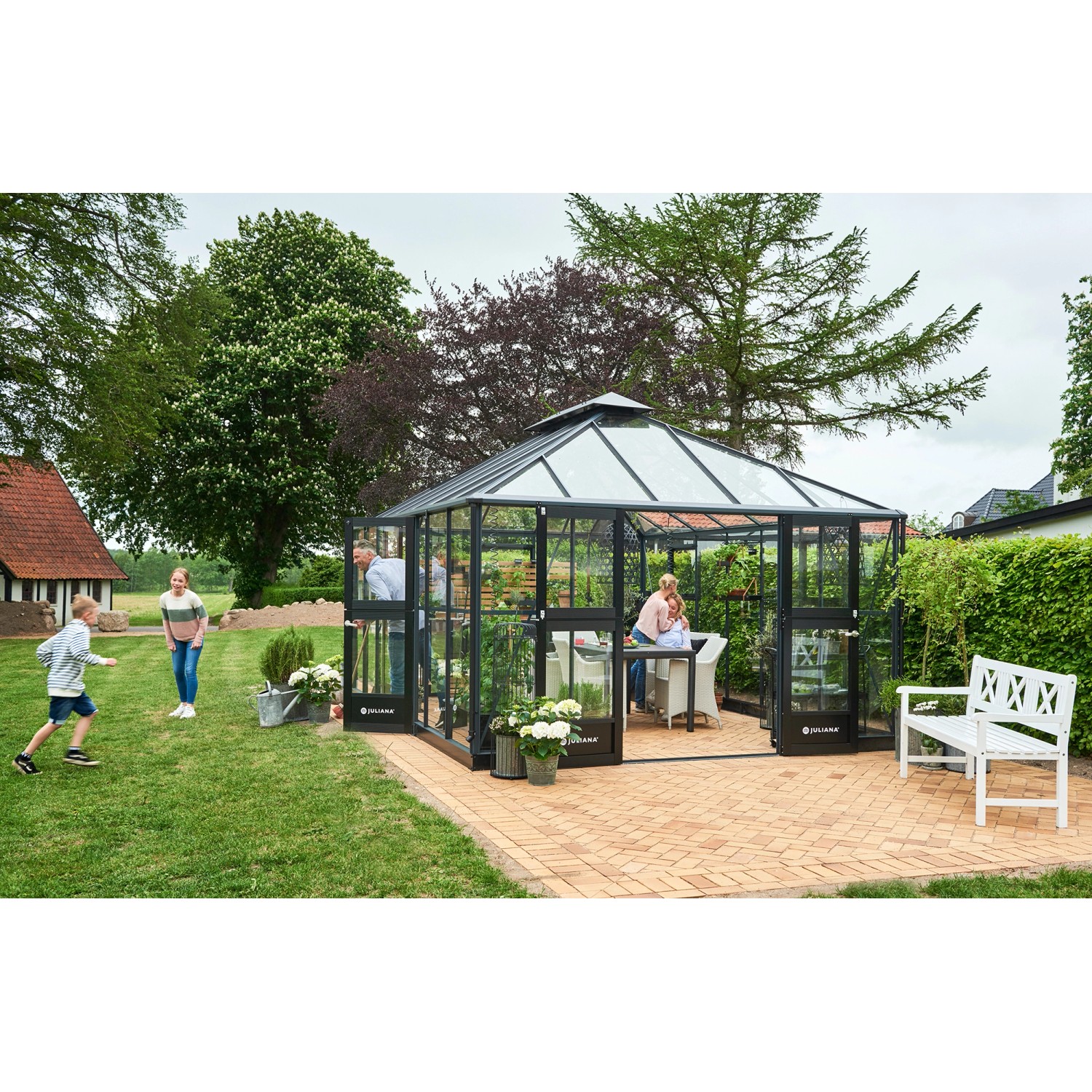 Großes, anthrazitfarbenes Juliana Gewächshaus Grand Oase 18 mit Fundamentrahmen im Garten.