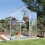 Silbernes Palram Canopia Gewächshaus 2,3 m² mit Pflanzen und Fundamentrahmen im Garten.