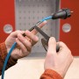 Anwendung von selbstverschweißendem Isolierband (schwarz) an einem Kabel.