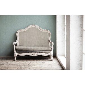 Türkise Vliestapete mit Muster an Wand hinter antikem Sofa. Dekorative Tapete.