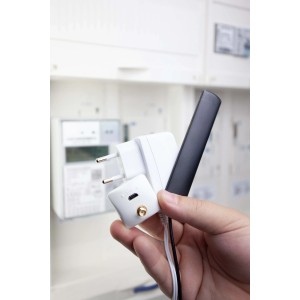 poweropti Stromzählerauslesegerät in Hand vor Stromzähler. Smart Home Set zur Energieüberwachung.