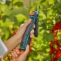 Gardena Assistcut Gartenschere in Aktion: Batterieunterstützte Schere schneidet Zweig.