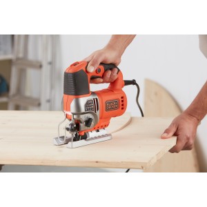 Black+Decker Stichsäge BES610K beim Sägen von Holz. Elektro-Pendelhub-Stichsäge mit orangenem Gehäuse.