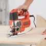 Black+Decker Stichsäge BES610K beim Sägen von Holz. Elektro-Pendelhub-Stichsäge mit orangenem Gehäuse.