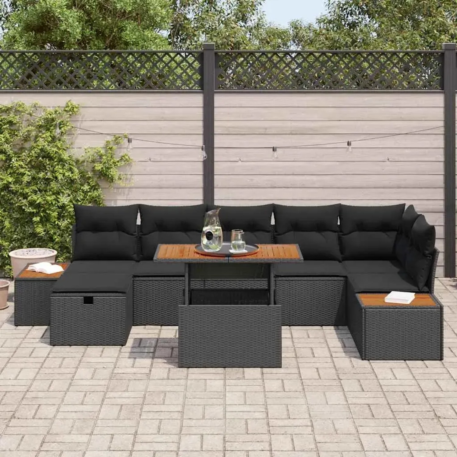 Schwarzes 8-teiliges Garten-Sofa-Set aus Poly Rattan mit Kissen und Tisch.