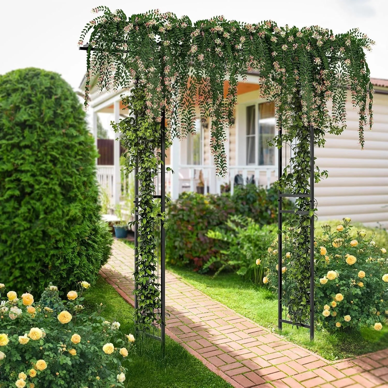 Schwarzer Costway Rosenbogen aus Metall, bewachsen mit Kletterpflanzen, als Rankhilfe im Garten.