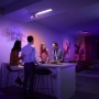 Philips Hue Centris LED-Deckenleuchte mit 3 Spots in Weiß im Wohnraum mit farbiger Beleuchtung.