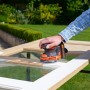 Black+Decker Akku-Exzenterschleifer BDCROS18 beim Schleifen eines Fensterrahmens.