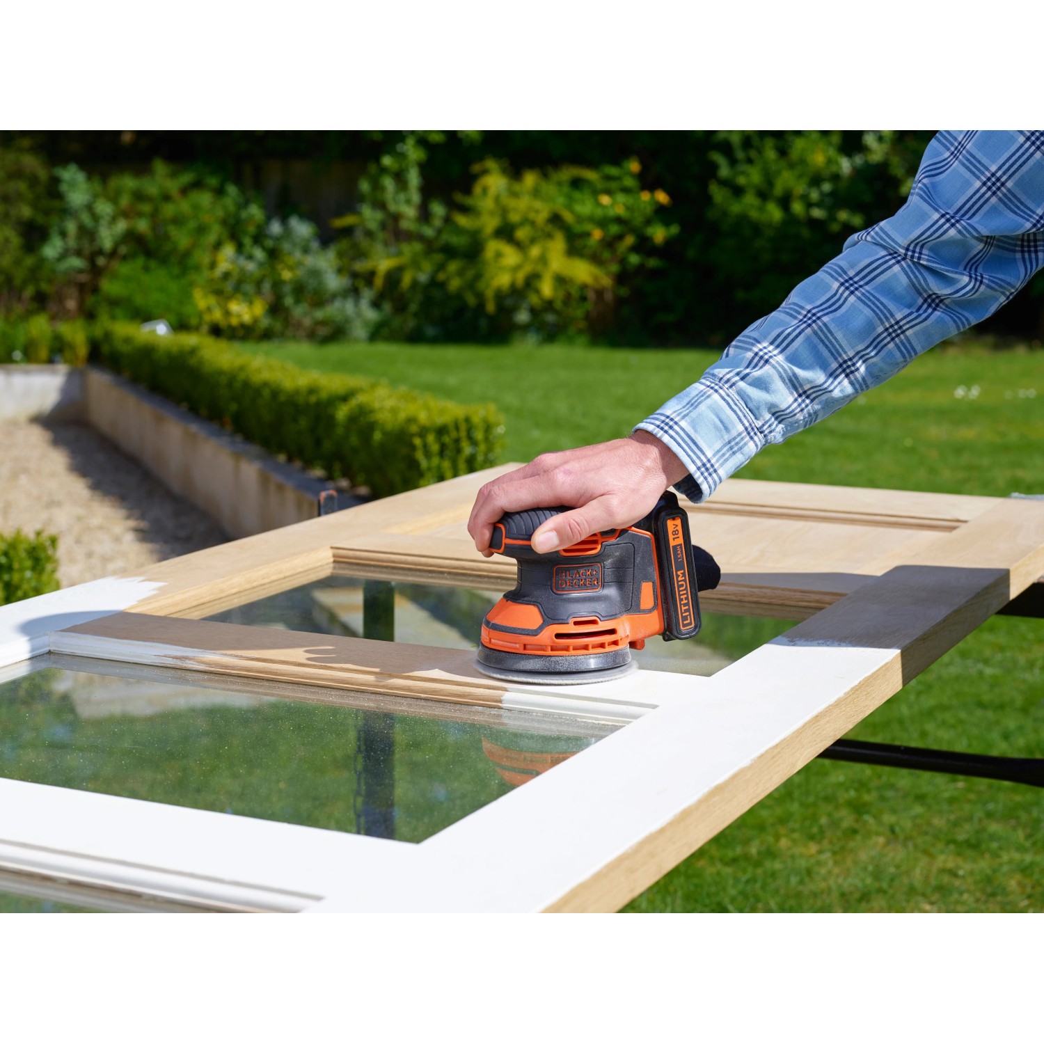Black+Decker Akku-Exzenterschleifer BDCROS18 beim Schleifen eines Fensterrahmens.