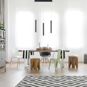 Schwarze, 3-flammige LED-Pendelleuchte Bruno über Esstisch im Wohnraum.