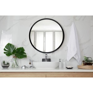 Runder Tulup Wandspiegel mit schwarzem Rahmen über einem Waschbecken im Badezimmer. Eleganter Designer Spiegel.