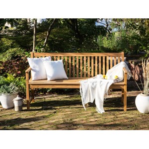 Helle Holzfarbene Beliani Gartenbank VIVARA (61x160x88) mit Kissen und Decke im Garten.