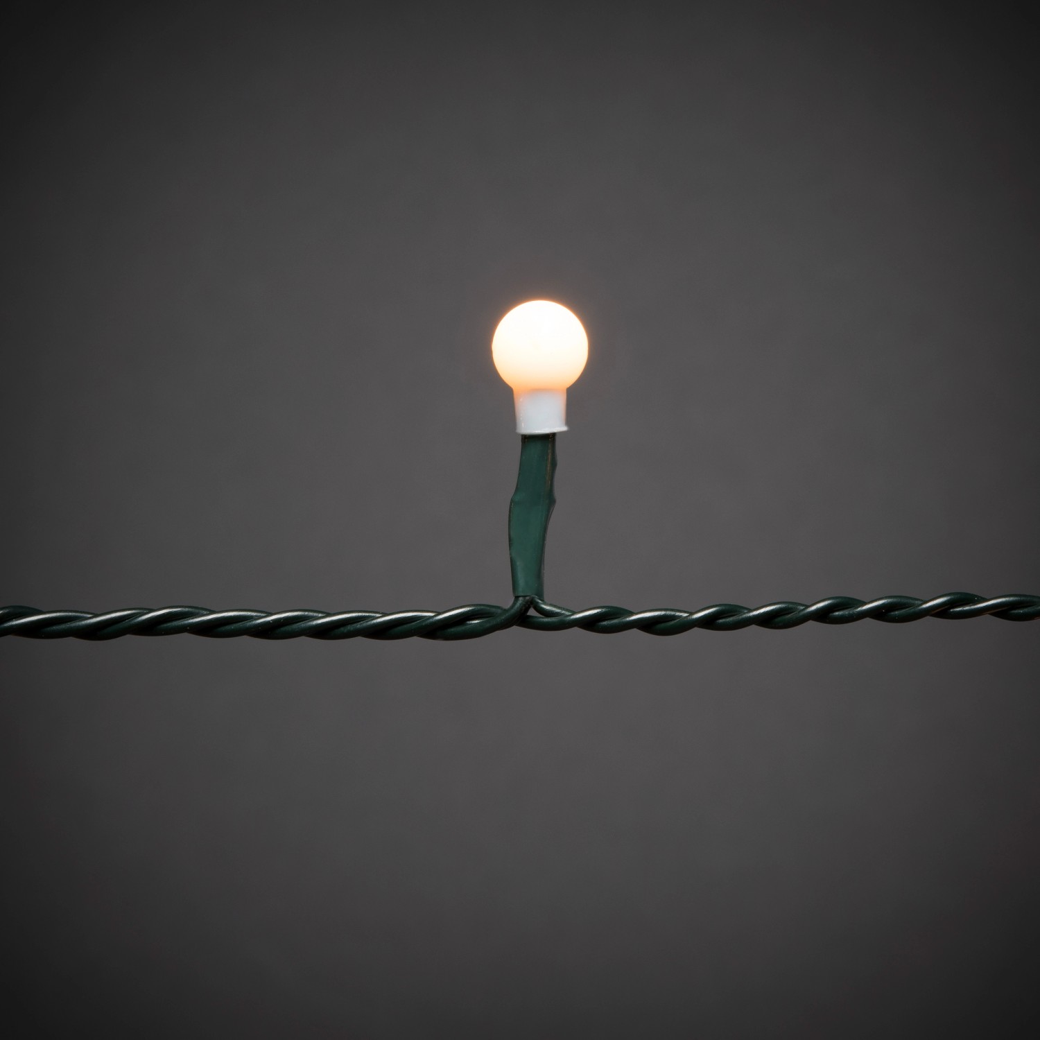 Nahaufnahme: Einzelne bernsteinfarbene LED Globe einer Lichterkette für den Innenbereich.