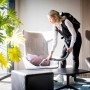 Frau saugt mit Kärcher Akku-Rucksacksauger BVL 5/1 Bp Tisch ab. Akkugerät für flexible Reinigung.