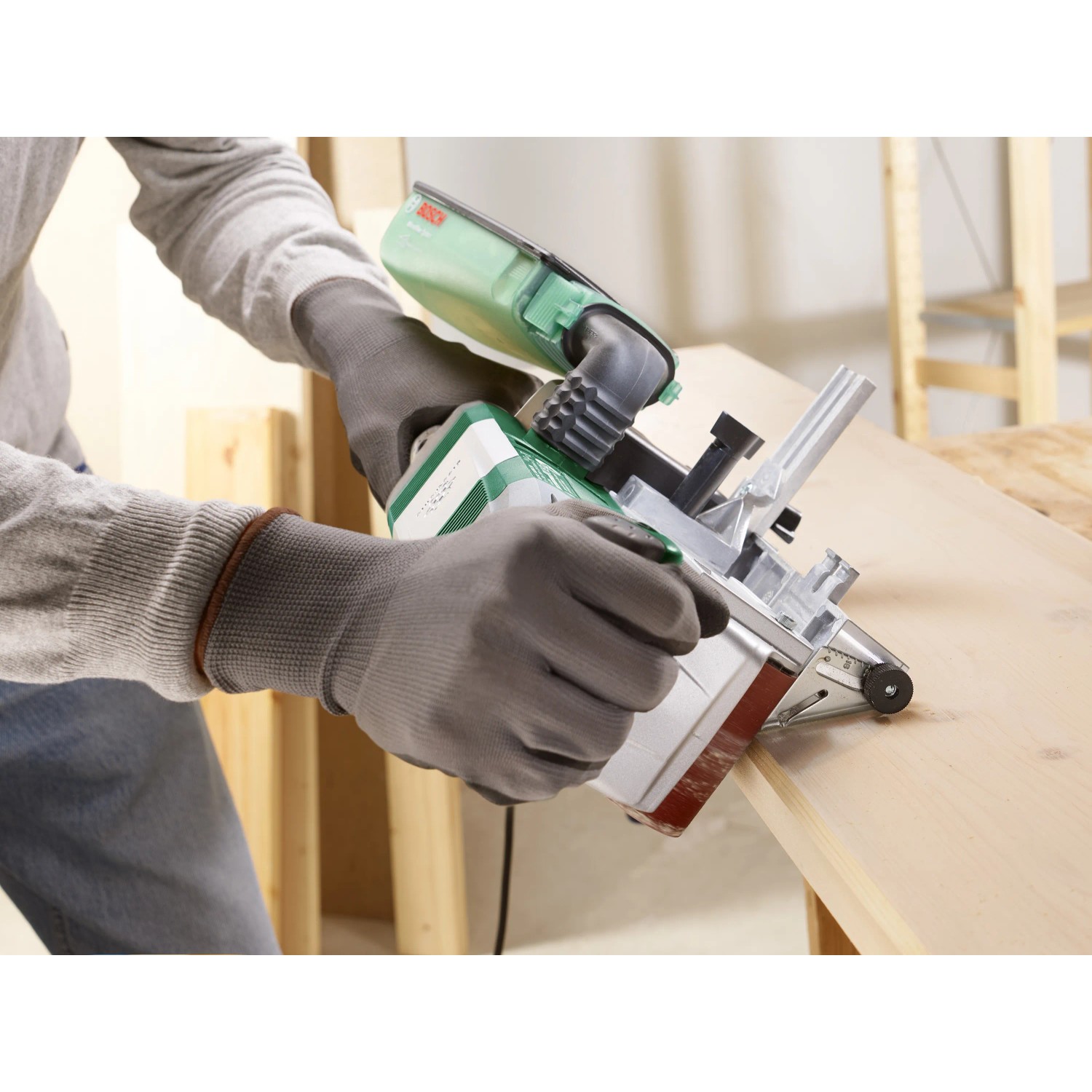 Bosch PBS 75 AE Bandschleifer im Einsatz mit Staubabsaugung und Parallelanschlag.
