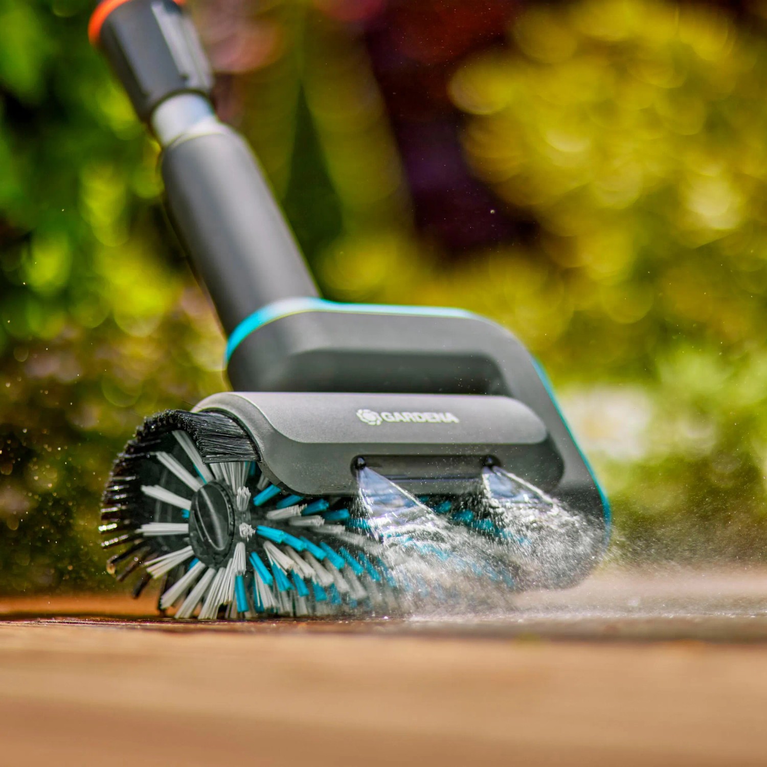 Gardena Akku-Multi-Reiniger AquaBrush Patio in Aktion: Reinigt Holzterrasse mit Wasser.
