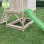 EXIT Loft 500 Holzspielhaus mit Sandkasten und grüner Rutsche im Garten.