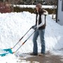 Frau schiebt Schnee mit Gardena Schneewanne 70 cm. Schneeschieber mit Stahlkante.