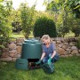 Grüner Garantia Schnellkomposter 280 l mit Frau bei der Kompostentnahme im Garten.