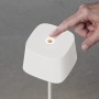 Weiße Konstsmide LED Tischleuchte Capri mit Finger auf dem Touch-Sensor. Außen-Dekoleuchte, dimmbar.
