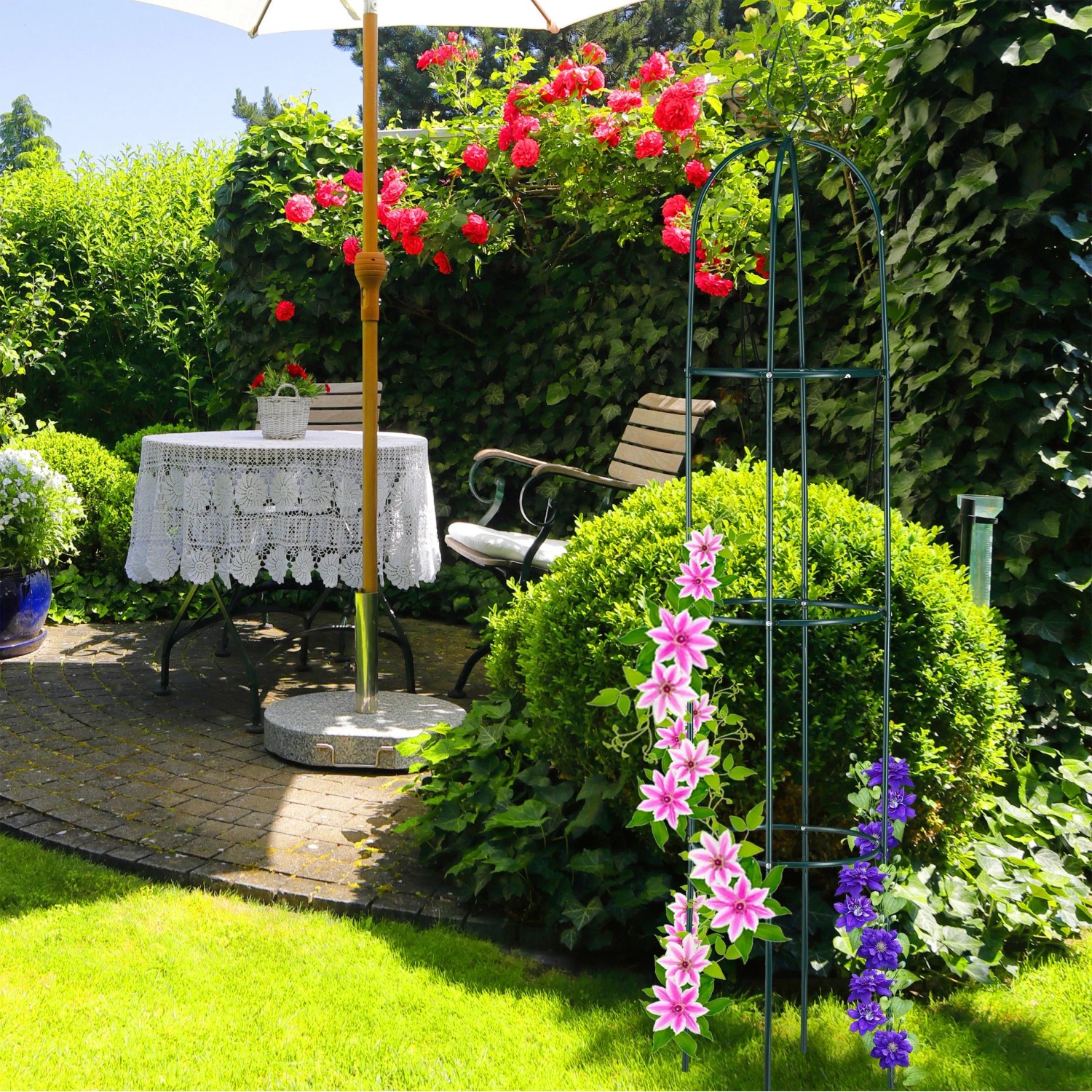 Dunkelgrüner Stahl Rankobelisk, 200 cm, mit Kletterpflanzen im Garten. Robuste Rankhilfe für Rosen und Clematis.
