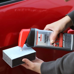 Nigrin Hartwachs-Politur wird auf einen Schwamm gegeben, um Autolack zu pflegen.