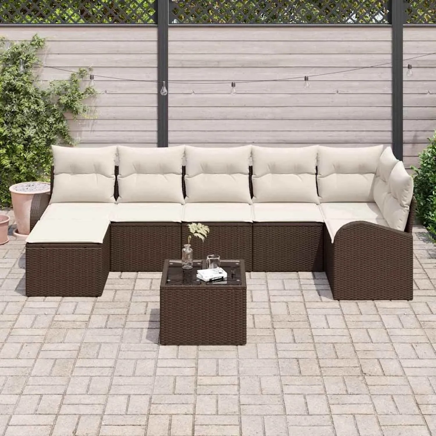Braunes 8-teiliges Garten-Sofa-Set aus Rattan mit beigen Kissen und Tisch.