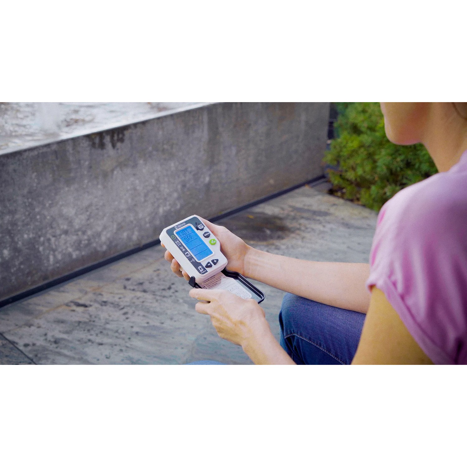 Geka Bewässerungscomputer mit Hahnadapter in der Hand, zur Steuerung der Gartenbewässerung.