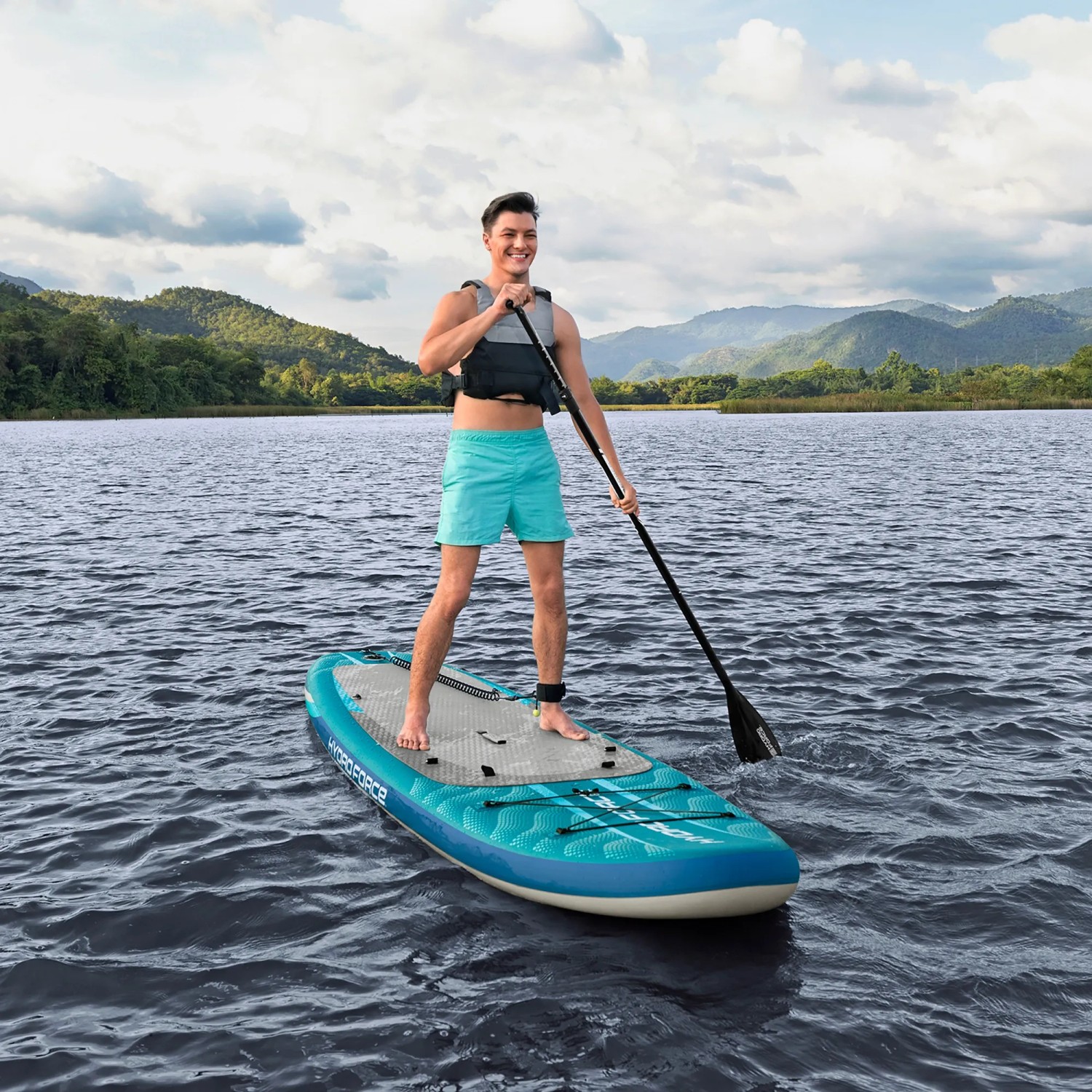 Mann auf Bestway SUP Board Aqua Drifter mit Sitz und Paddel auf dem Wasser.
