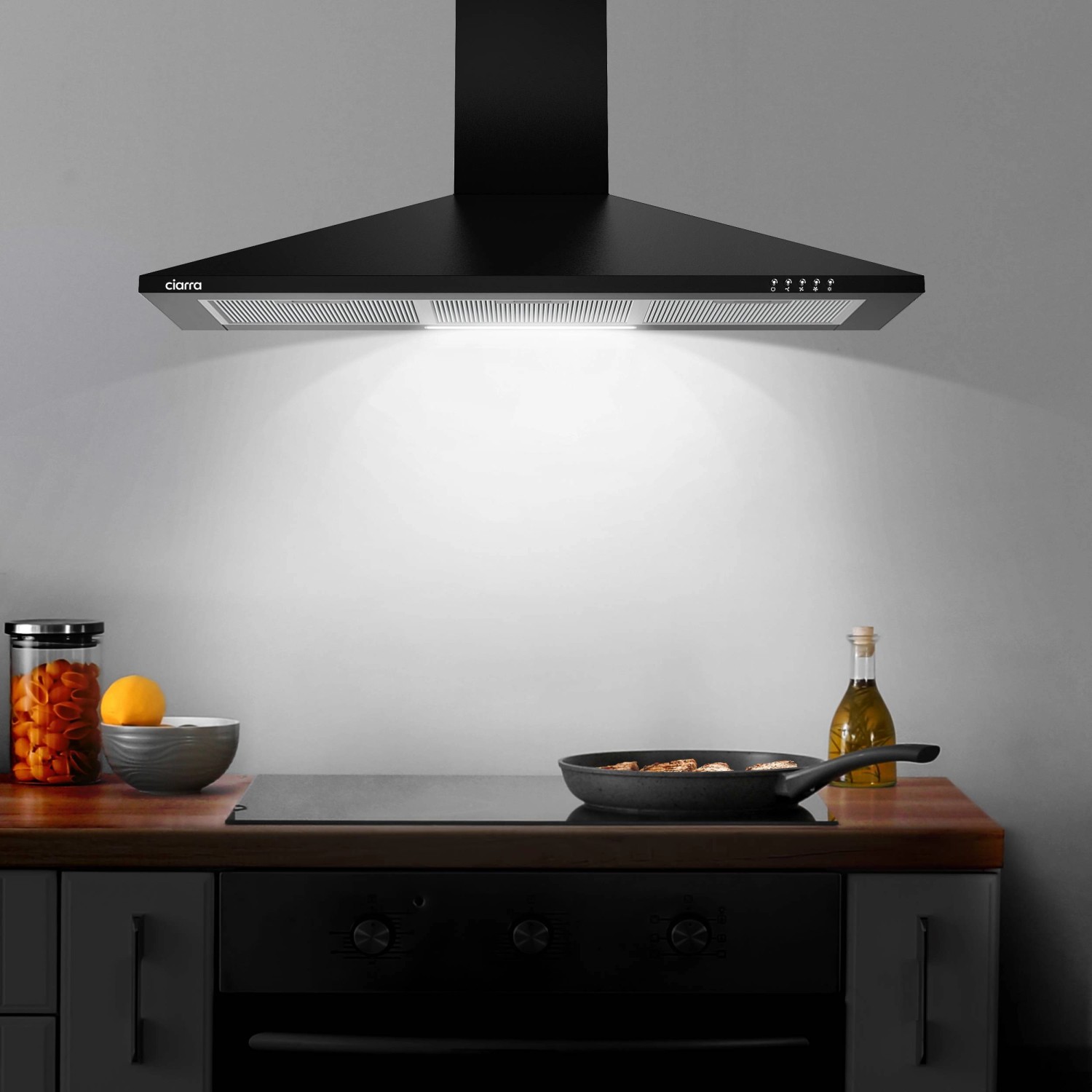 Schwarze CIARRA Dunstabzugshaube (90cm) über Kochfeld mit Speisen. A++ Energieeffizienz, 370 m³/h.