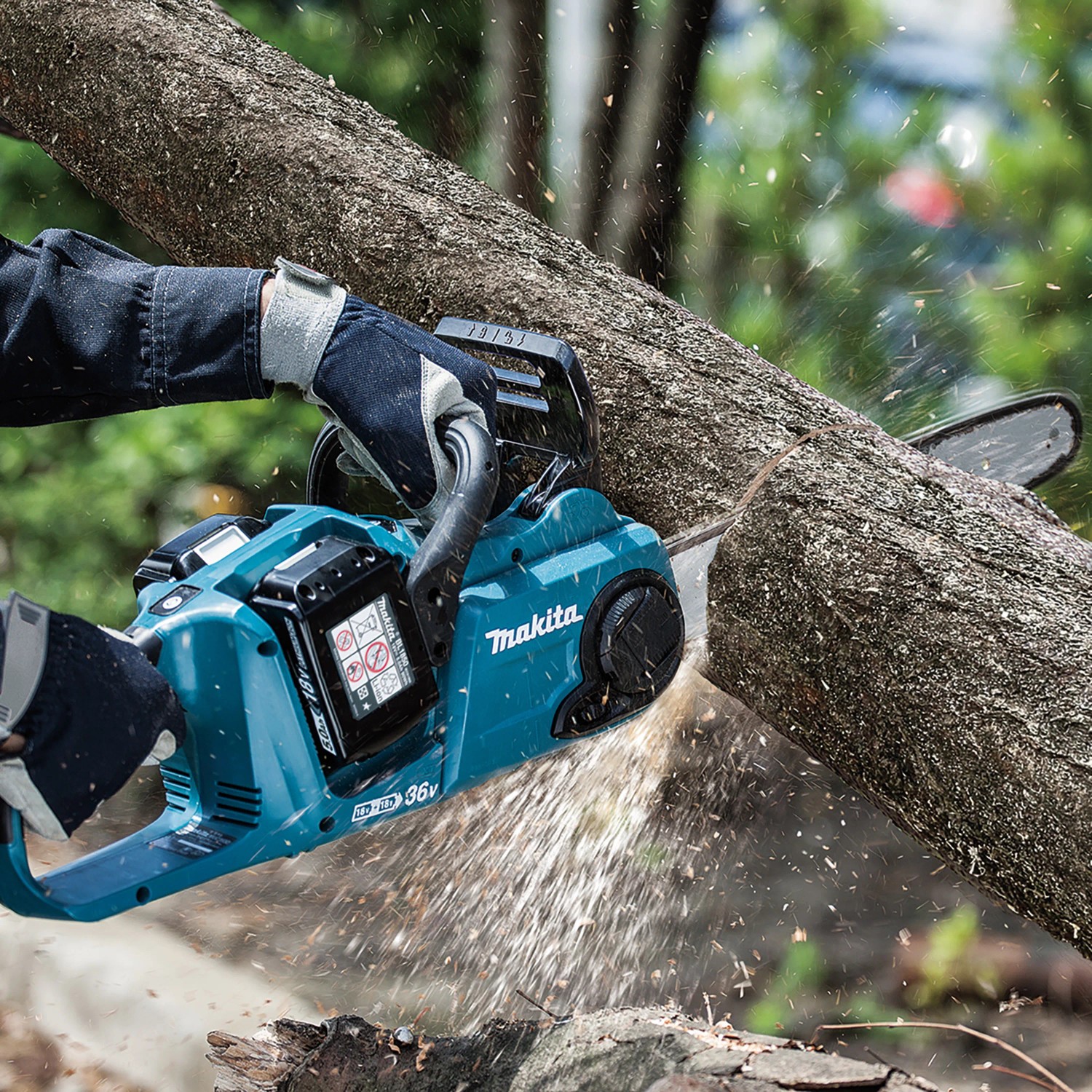 Makita Akku-Kettensäge DUC353Z im Einsatz beim Sägen von Holz. Die Kettensäge ist blaugrün und schwarz.