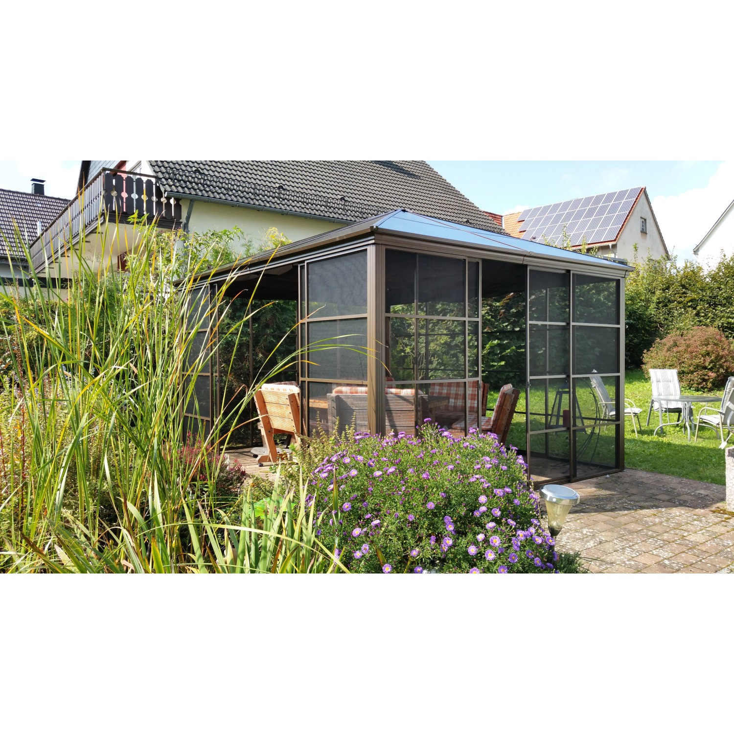 Bronzefarbener Sojag Aluminium Pavillon Castel 12x14 mit Moskitonetz und Schiebetüren im Garten.