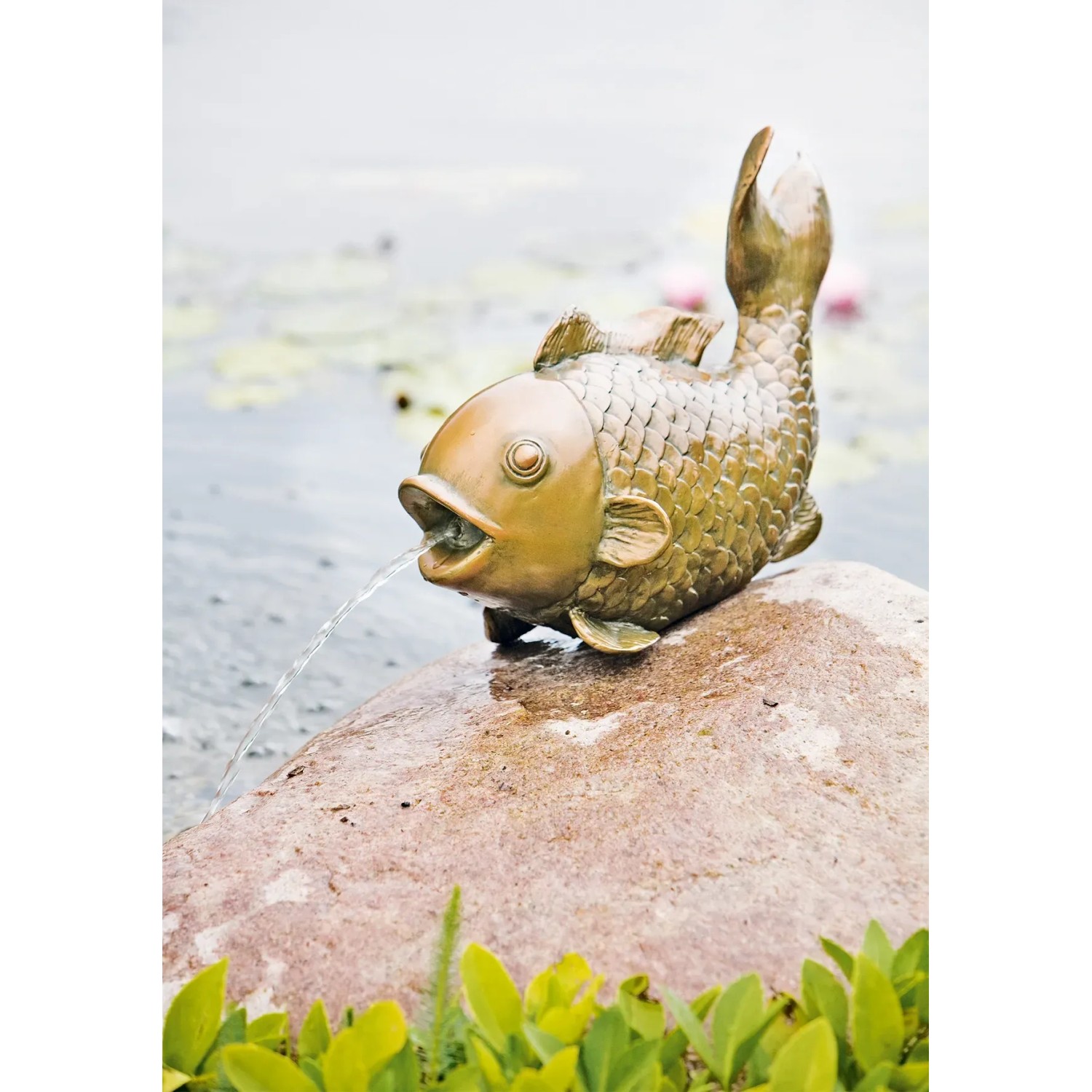 Heissner Teichfigur "Großer Fisch" aus Polyresin, kupferfarben, als Wasserspeier auf einem Stein.