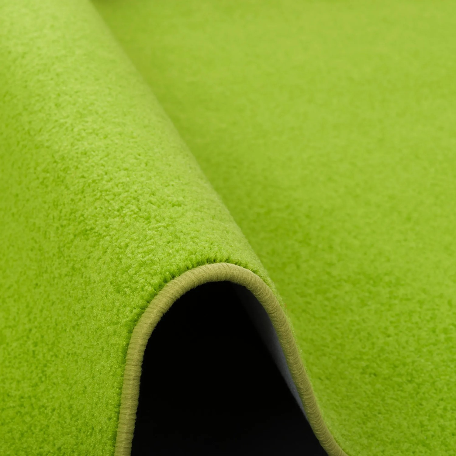 Grasgrüner Snapstyle Teppich Joy Velours, 133x133cm, Detailansicht der Teppichstruktur und Kettelung.