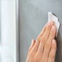 Anbringen eines Tesa Powerstrips Haken Waterproof Zoom an einer Wand im Badezimmer.