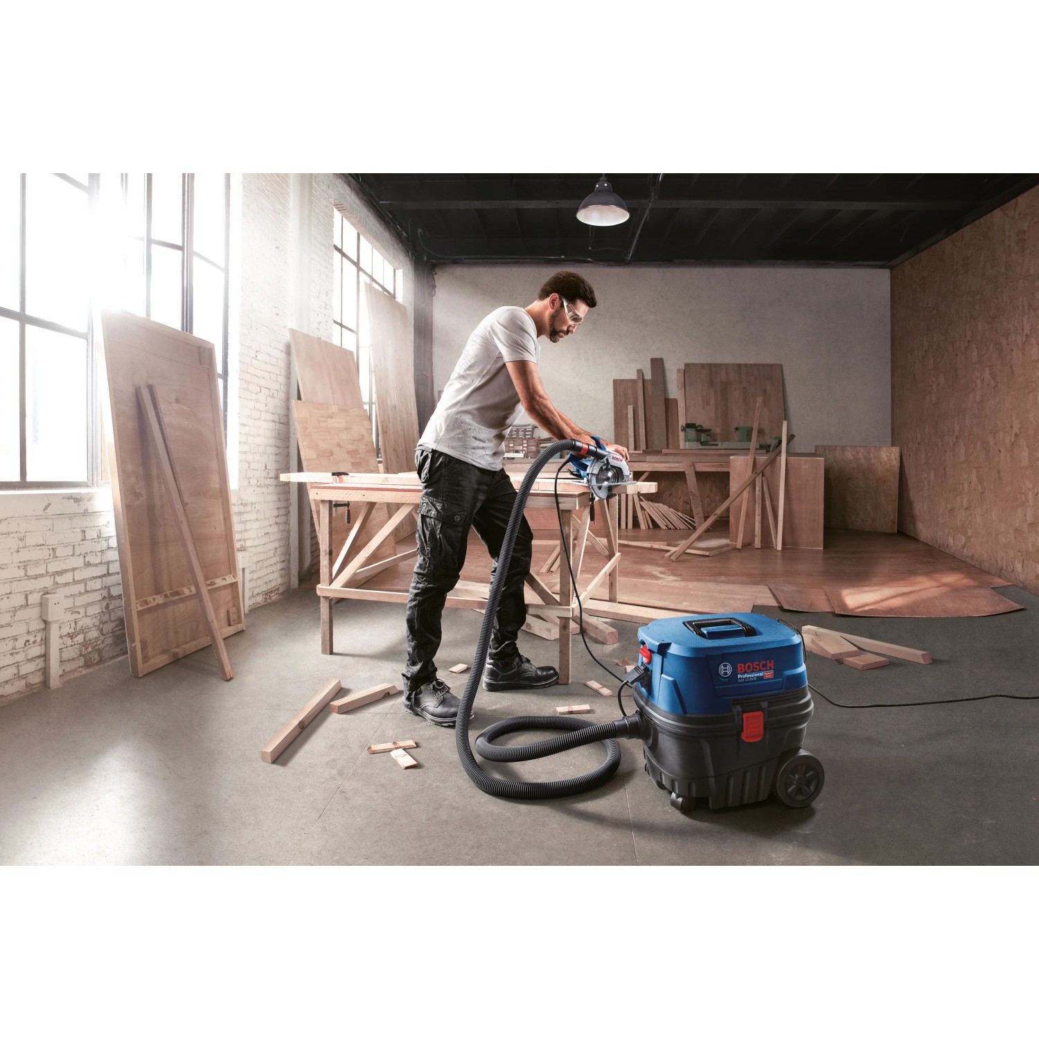 Bosch Professional GAS 12-25 PL Nass-/Trockensauger im Einsatz mit Handwerker beim Sägen.
