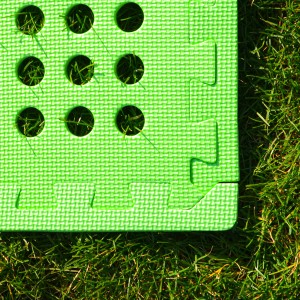 Grüne eyepower Poolmatte (4er Set, 62x62 cm) auf Rasen. Bodenschutzmatte für Pools.