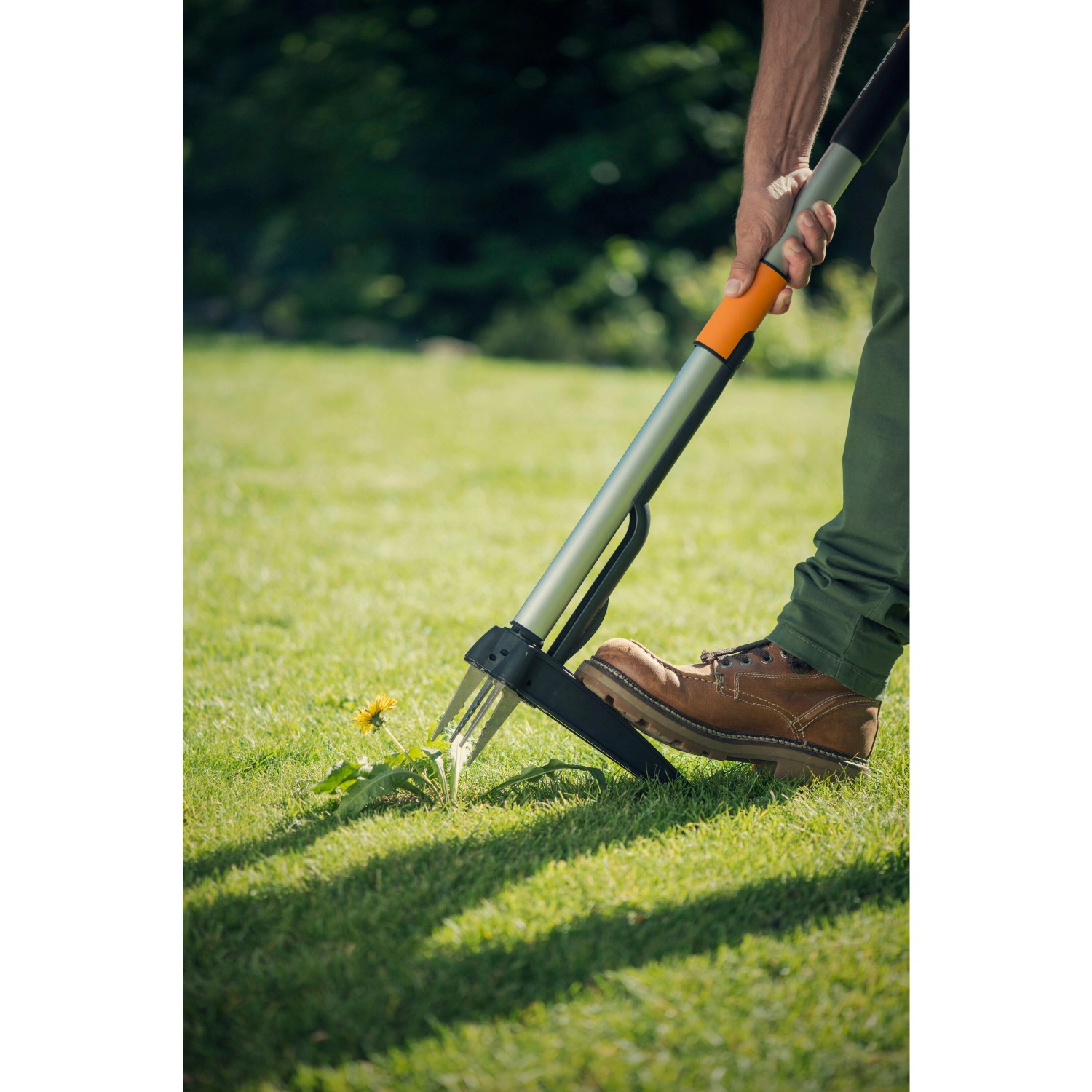 Fiskars Unkrautstecher Smartfit im Einsatz: Unkrautentfernung im Garten mit Teleskopstiel für rückenschonendes Arbeiten.
