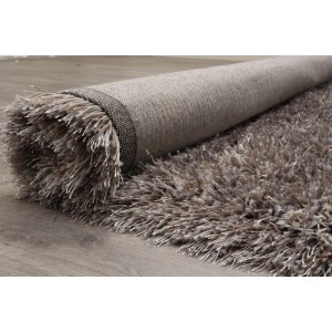 Aschgrauer Hochflor-Teppich aus Polyester, teilweise auf Holzfußboden ausgerollt. Kuscheliger Vercai Rugs Teppich.