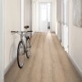 Verlegter Egger NatureSense Aqua Laminat in Braun im Flur mit Fahrrad an der Wand.