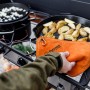 Petromax Aramid Topflappen Paar in Orange-Schwarz beim Grillen von Kartoffeln.