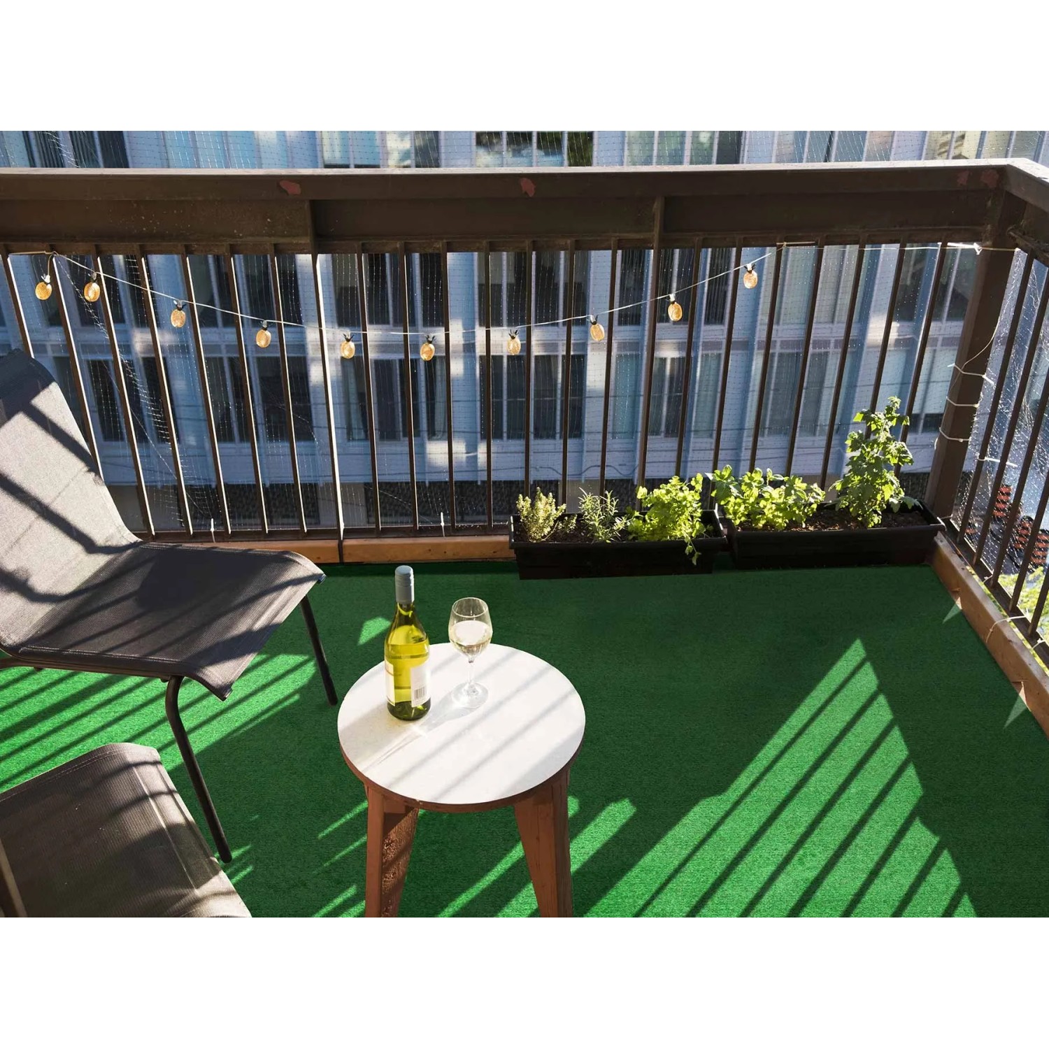 Grüner Primaflor Rasenteppich Park auf einem Balkon mit Tisch und Stühlen.